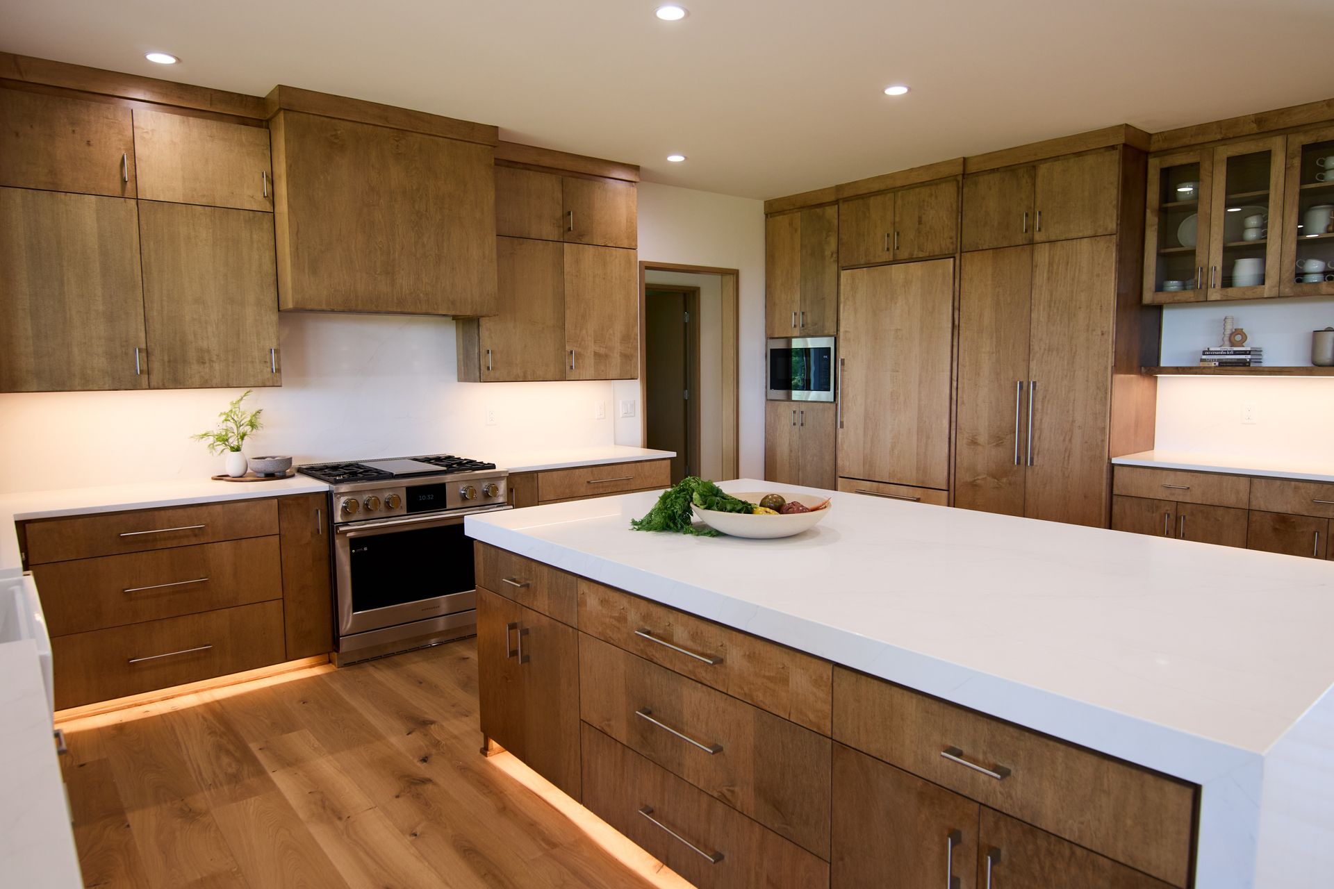 A kitchen with wooden cabinets and white counter tops