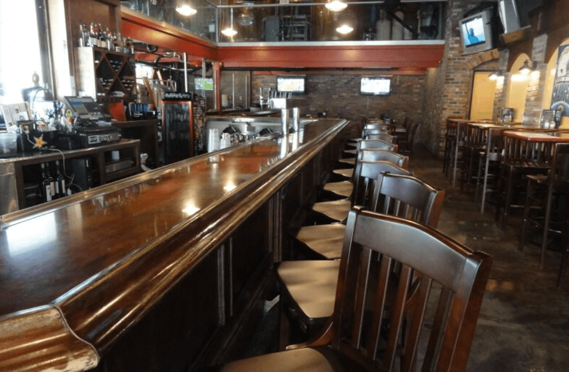 Bar stools lined up at the bar of Backstreet Brewery