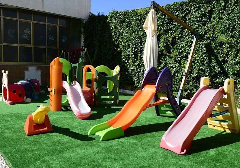 scivoli colorati in giardino con erbetta