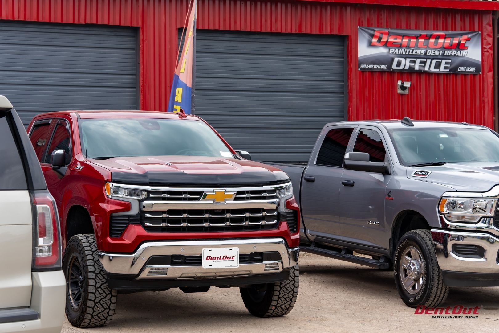 Two trucks are parked in front of a building.