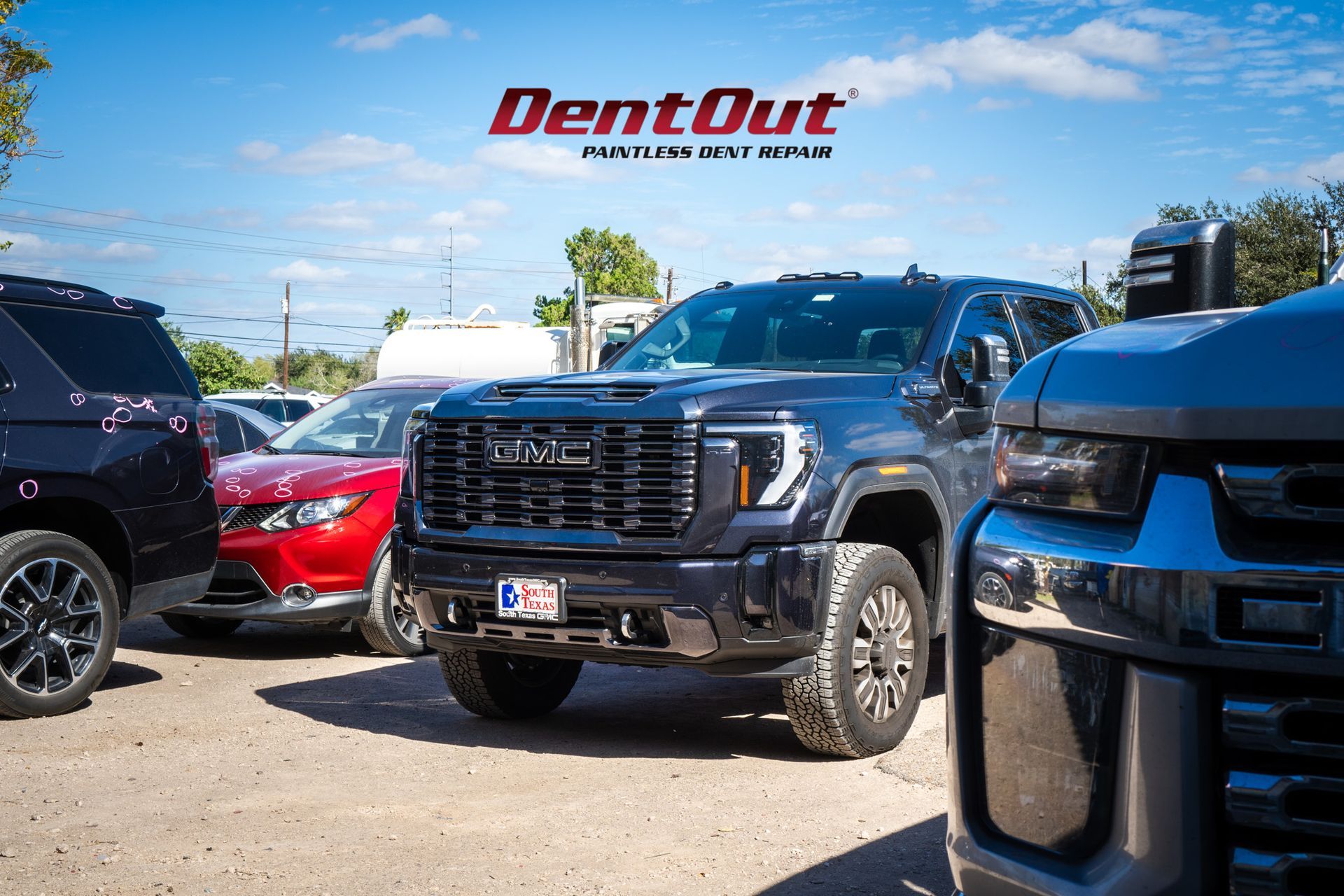 A gmc truck is parked in a parking lot next to other cars.