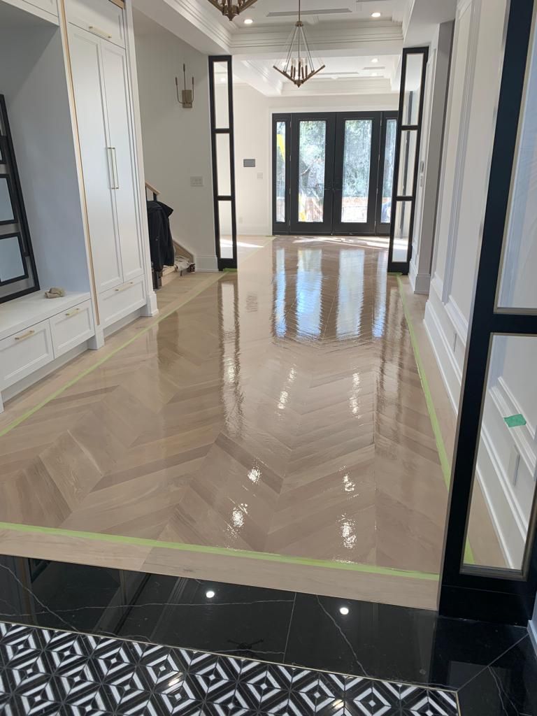 a large hallway with a wooden floor and a black and white rug .