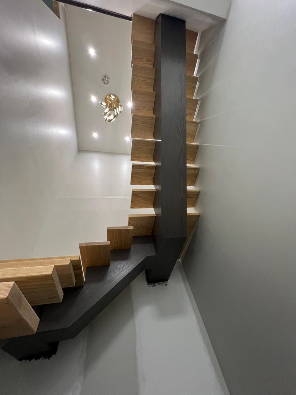 A staircase with wooden steps and a black railing