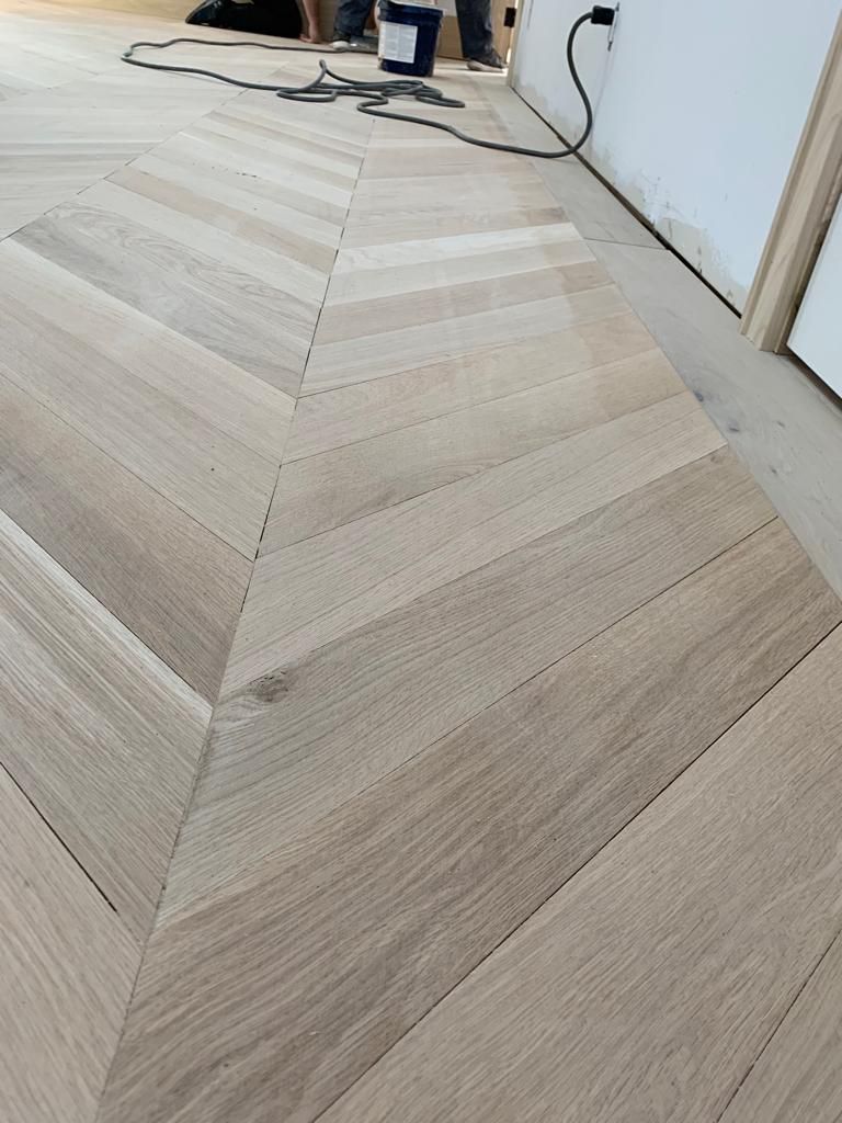 a close up of a wooden floor with a chevron pattern .