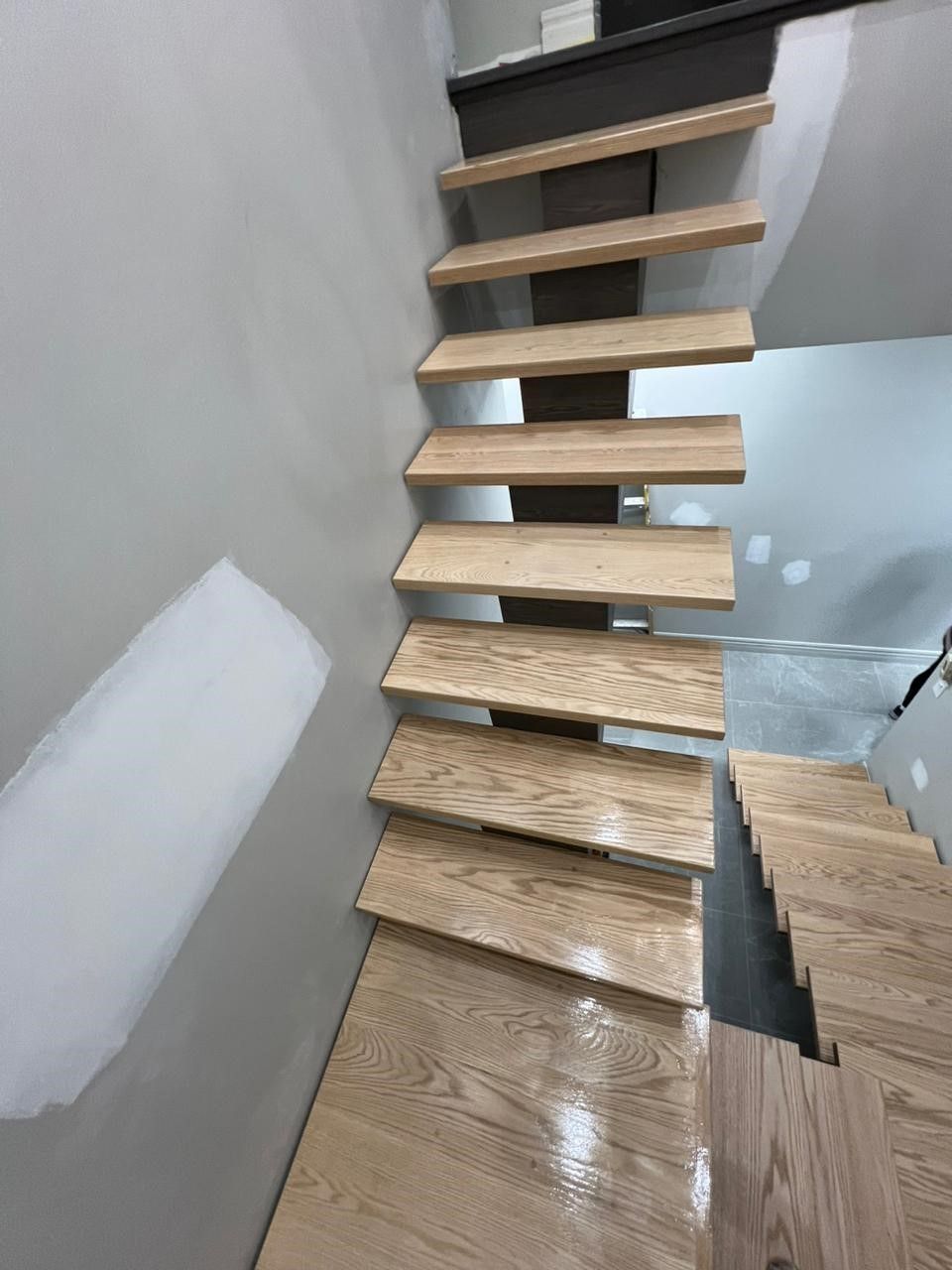 A wooden staircase is being built in a house.
