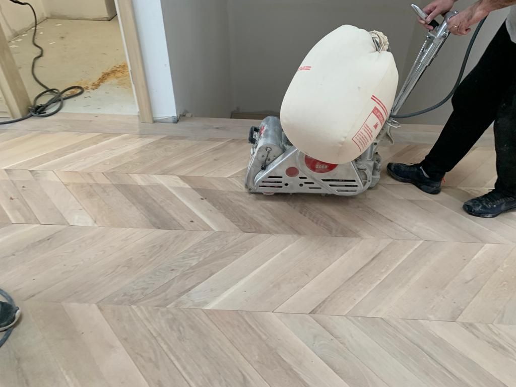 a person is using a machine to sand a wooden floor