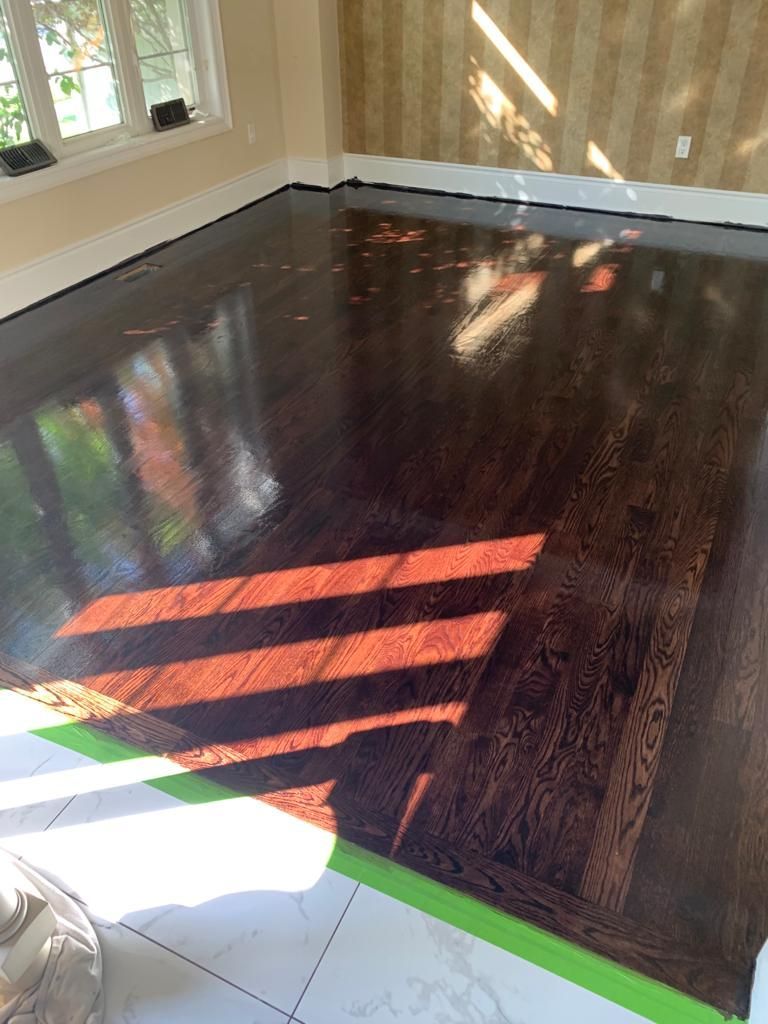 A living room with a wooden floor and a window.