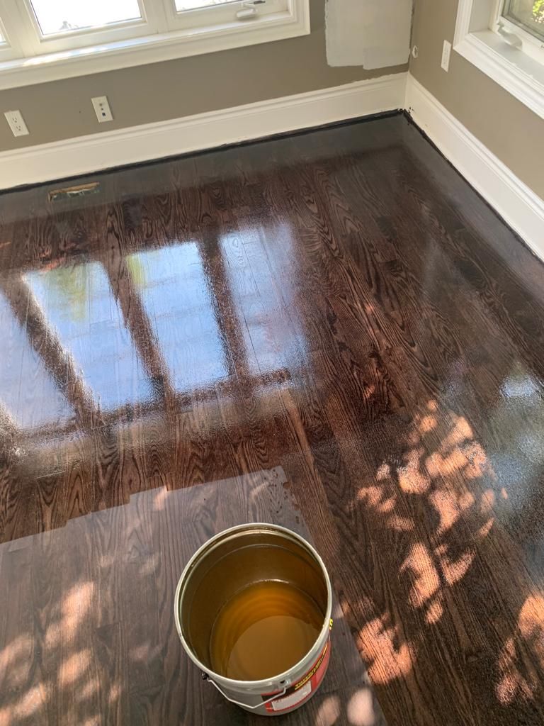 A bowl of wax is sitting on a wooden floor in a room.