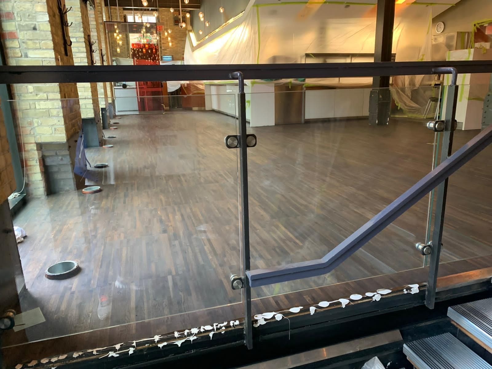 an empty room with a glass railing and stairs