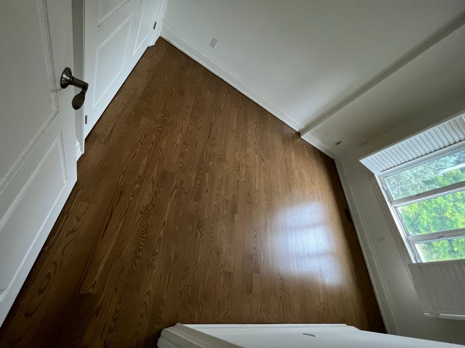 an empty room with hardwood floors and white walls .