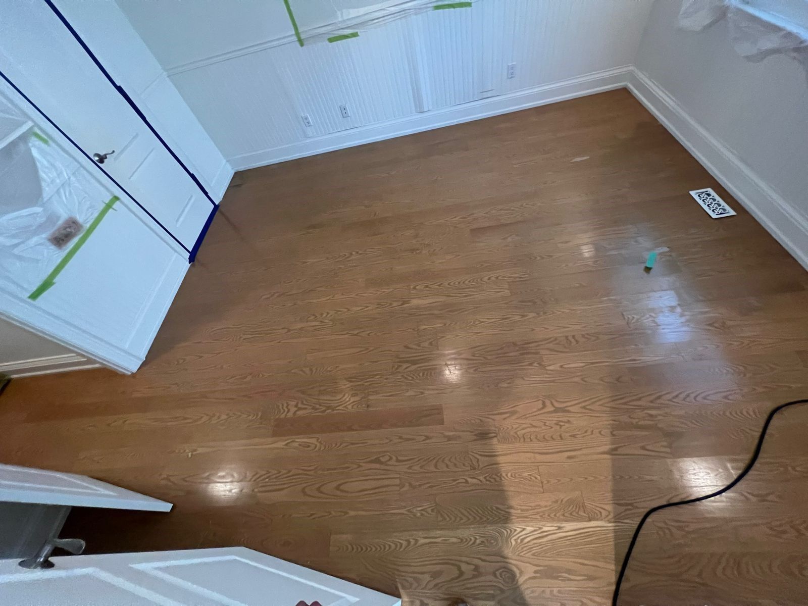 a room with hardwood floors and white walls .