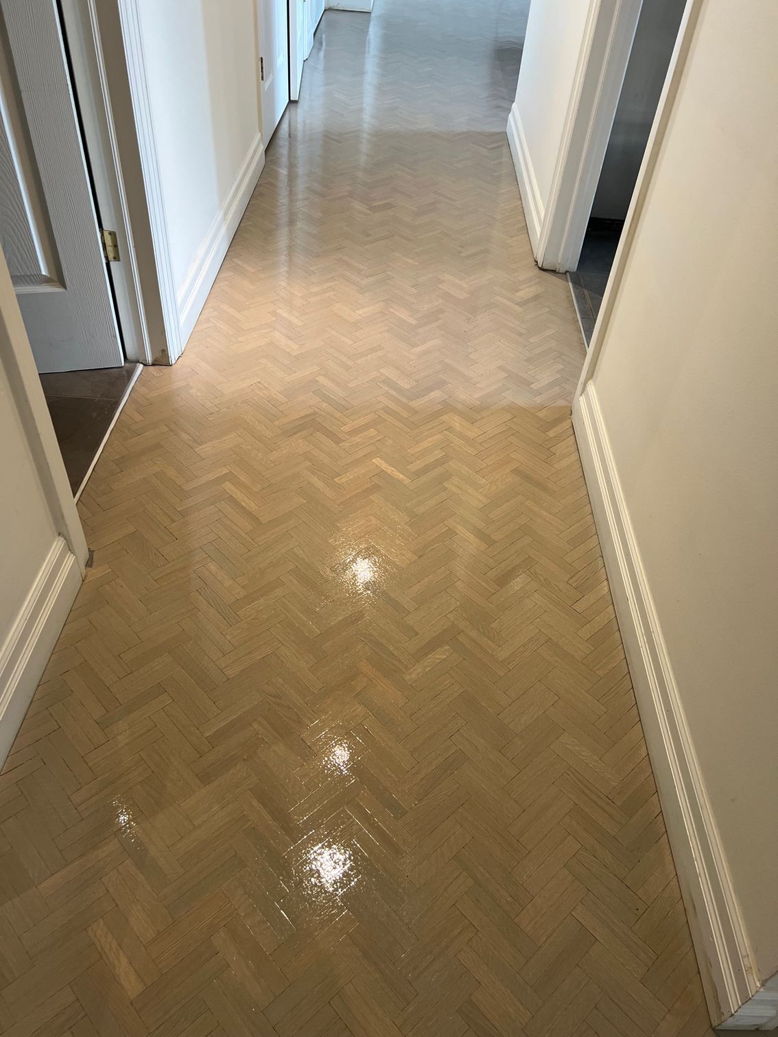 A hallway with a wooden floor and white walls