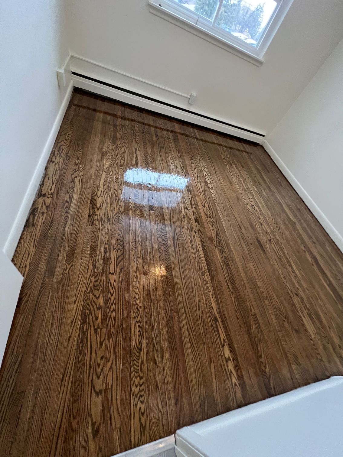 A room with hardwood floors and a window.