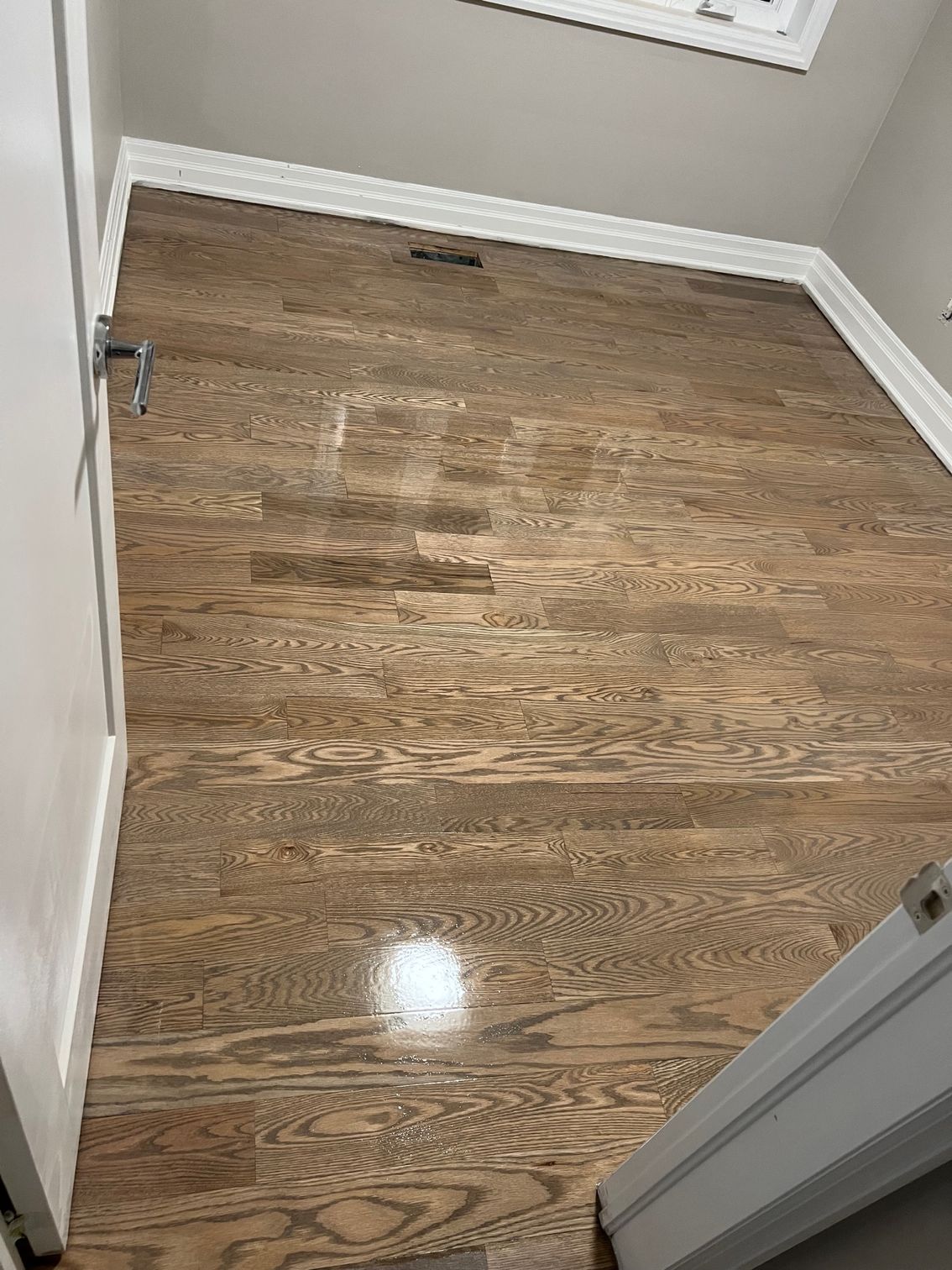 A room with hardwood floors and a white door.