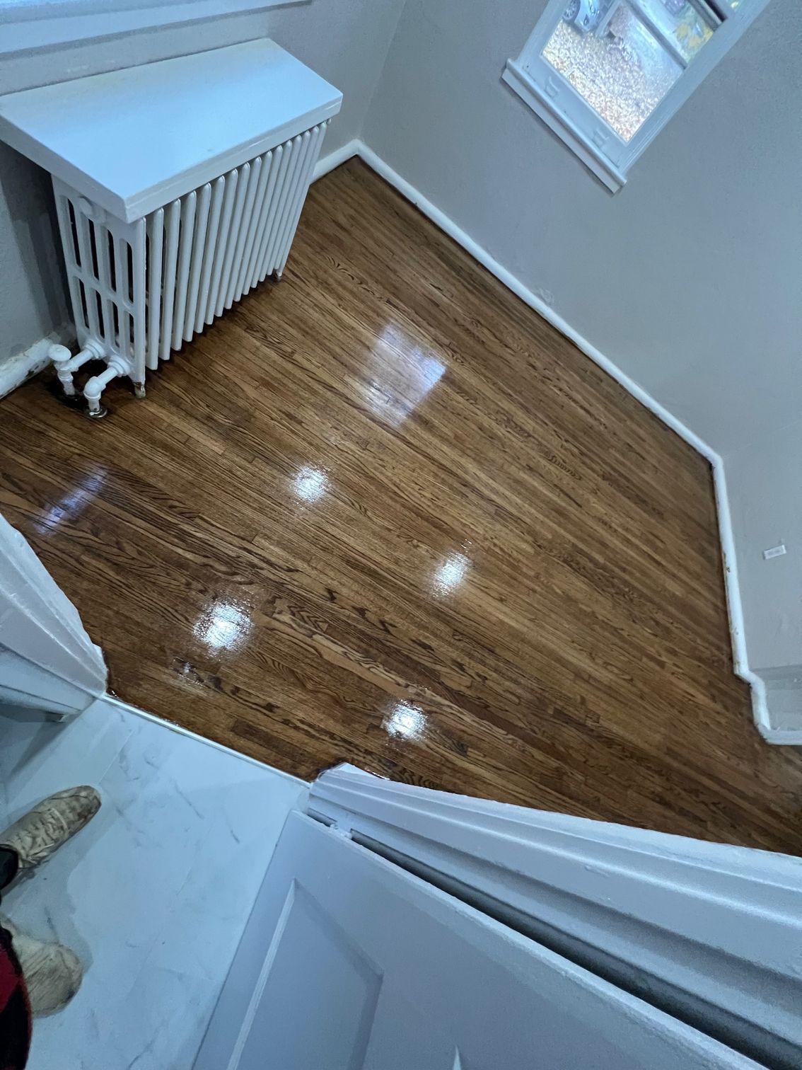 A room with hardwood floors and a radiator.