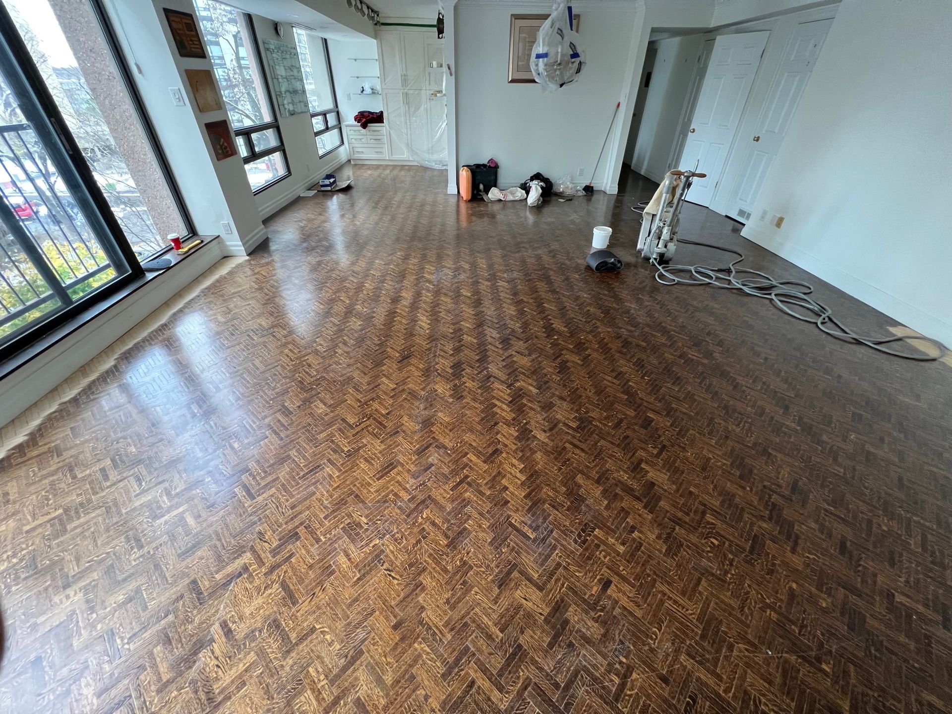 A living room with a wooden floor and a vacuum cleaner.