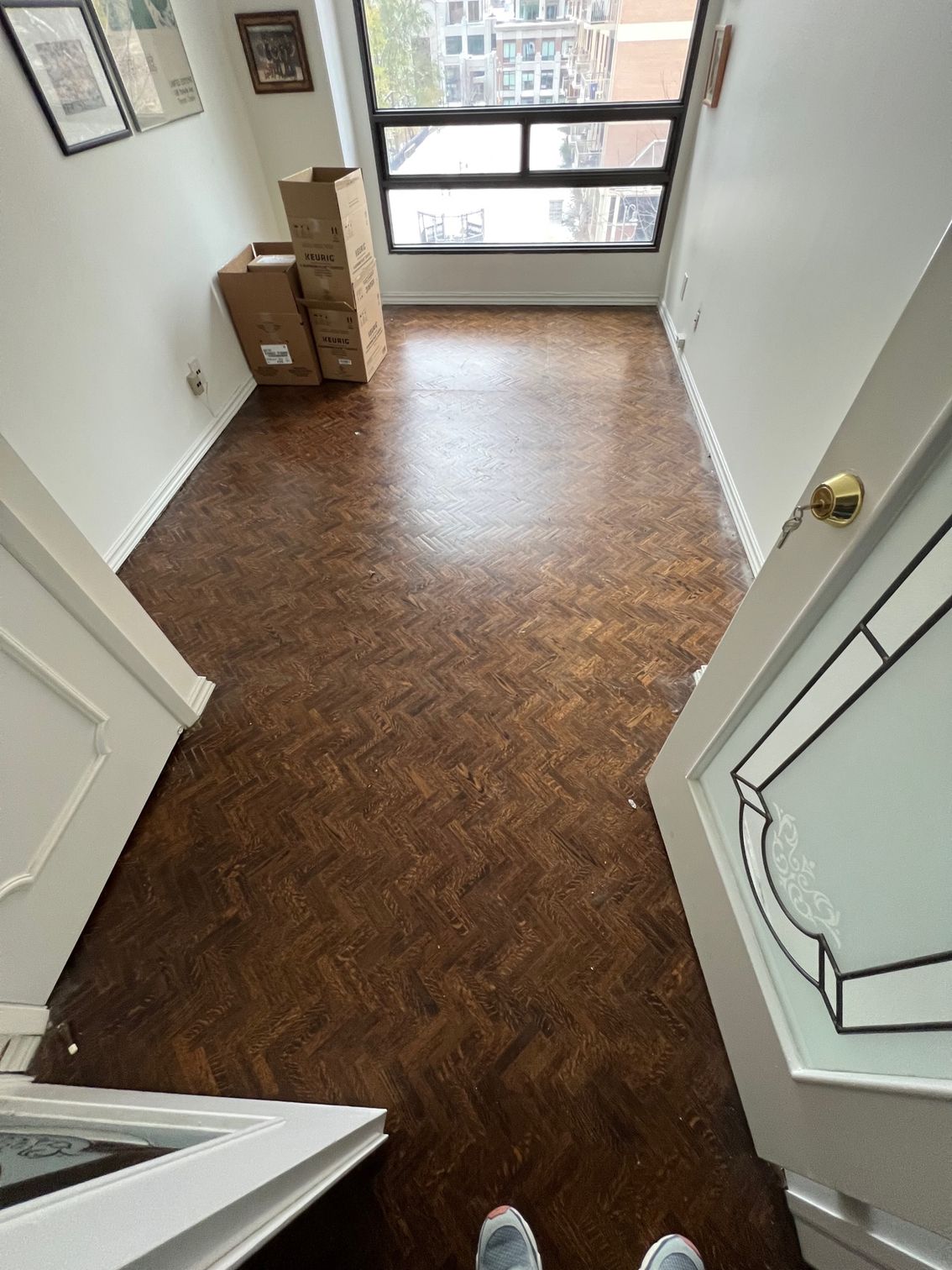 A person is standing in a room with boxes on the floor.