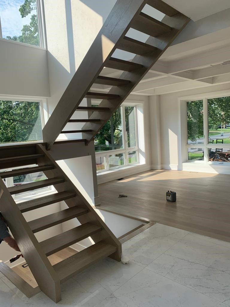 A wooden staircase in a room with lots of windows