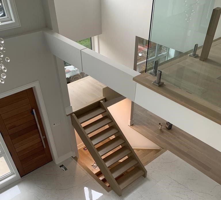 An aerial view of a wooden staircase with a glass railing