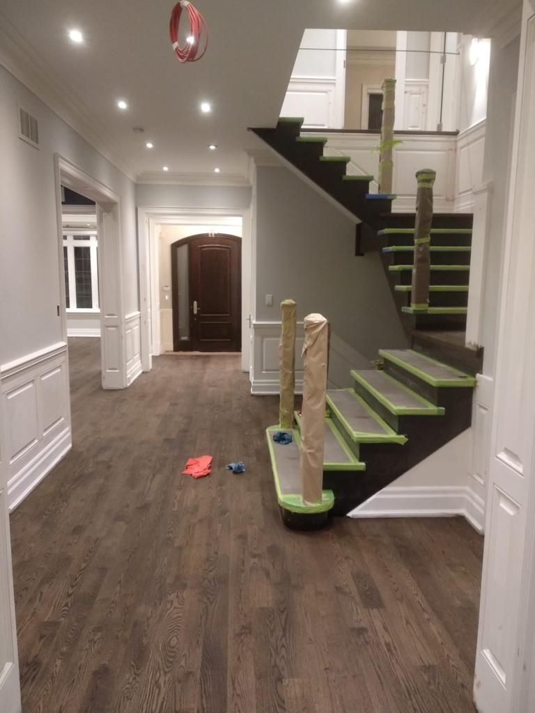 A staircase is being painted in a hallway in a house.