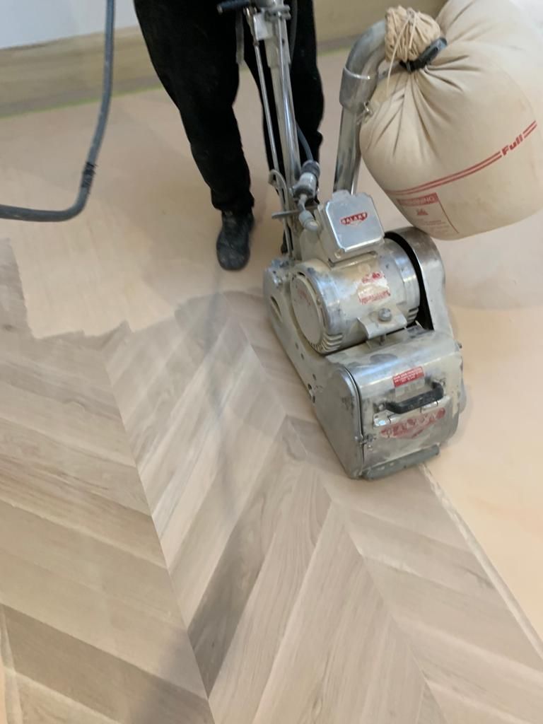 a person is sanding hardwood floor with a machine