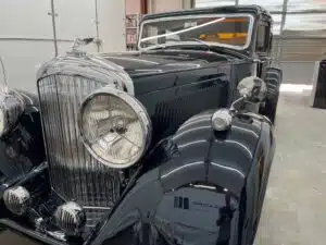 an old black car is parked in a garage .