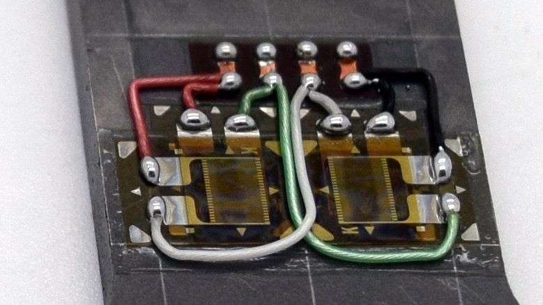 A close up of a black circuit board with multiple wires, used in the creation of load cells and instrumentation.