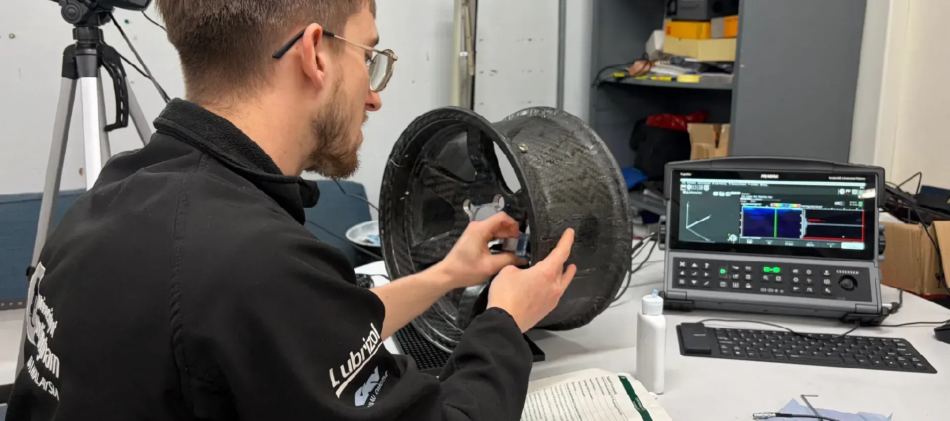 Team Lead from UoN racing working with a carbon fibre wheel from their formula student race car.