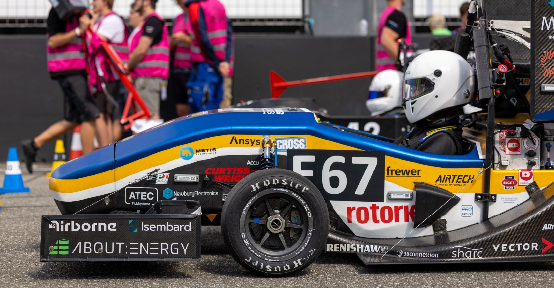 The team bath racing electric formula student race car on the start line with other competitors.