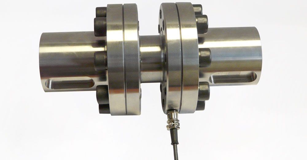 A close up of a stainless steel flange with a wire attached to it.