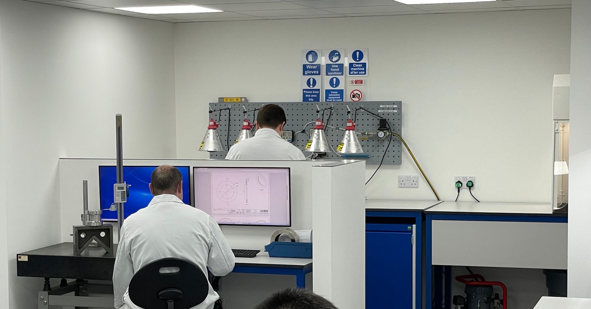 A man is sitting in front of a computer in a lab.