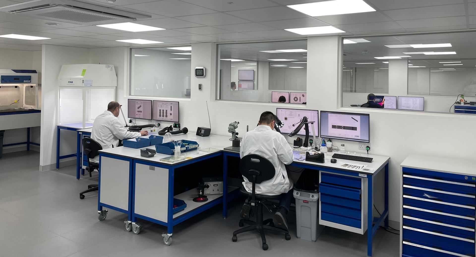 A group of people are sitting at desks in a lab.