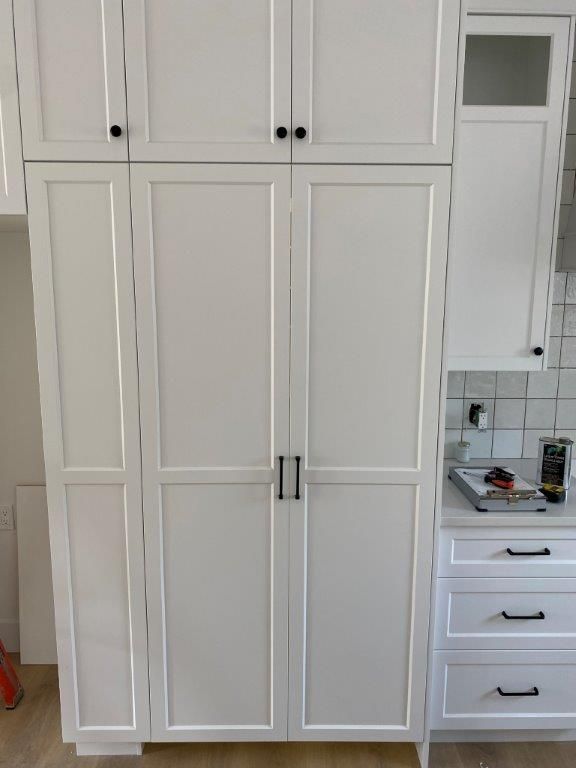 White kitchen cabinets with black hardware.