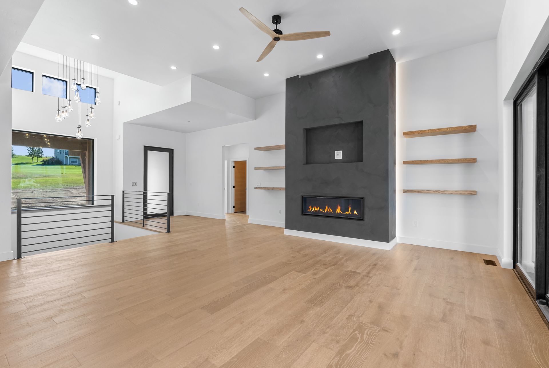 An empty living room with hardwood floors and a fireplace.