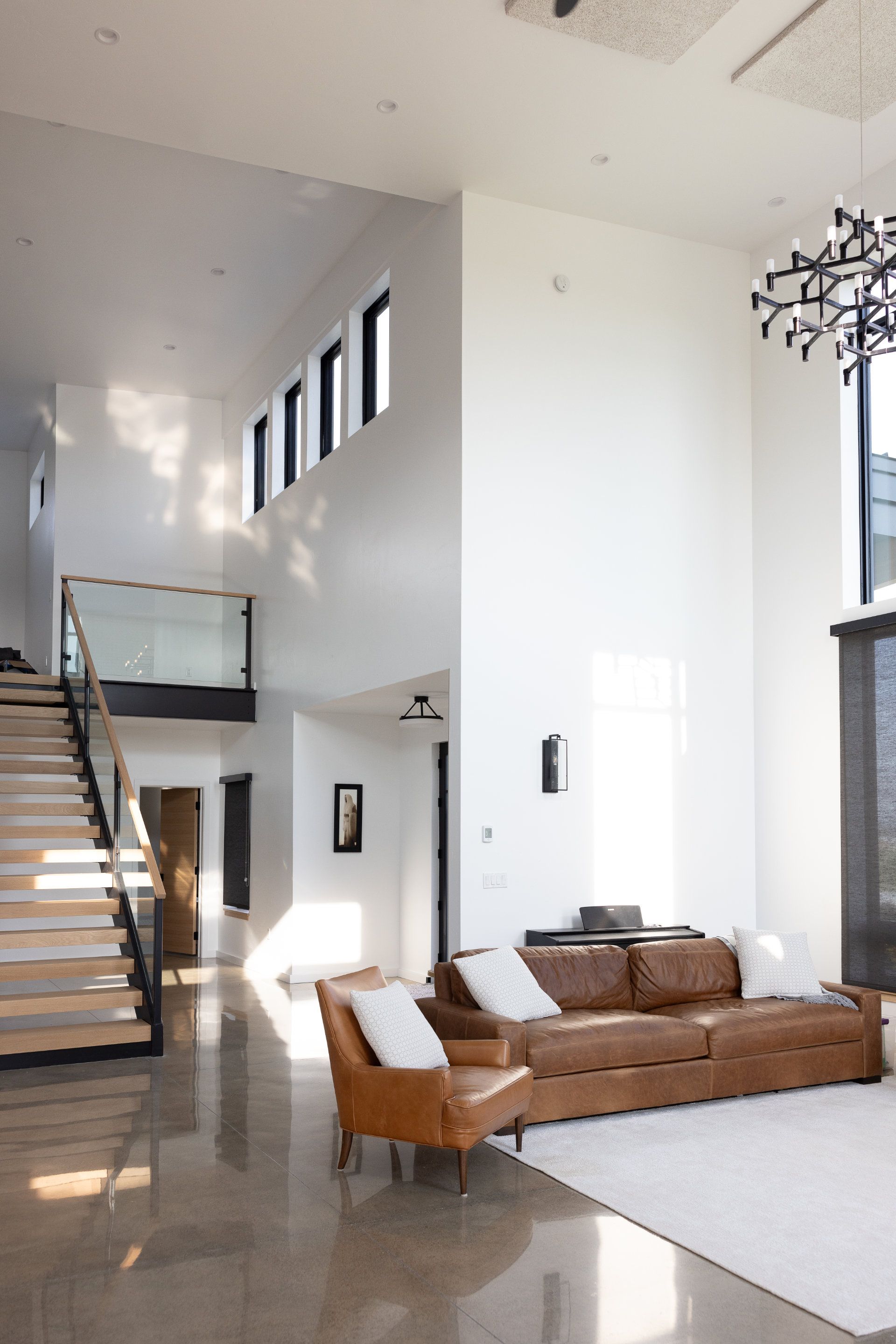 A living room with a couch and chairs and stairs