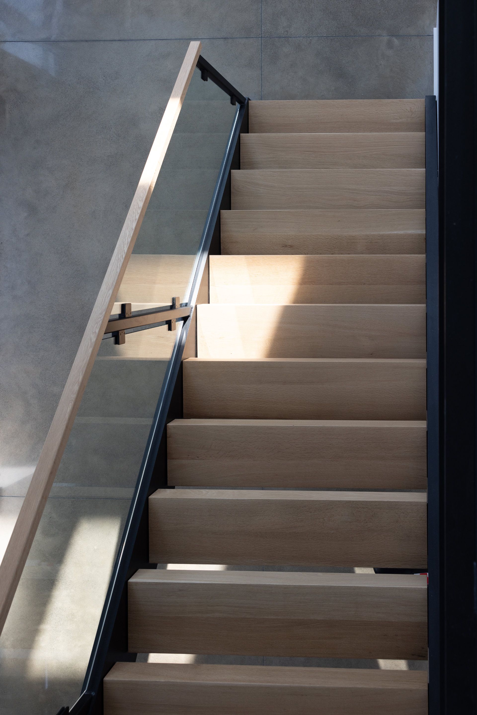 A staircase with a glass railing and wooden steps