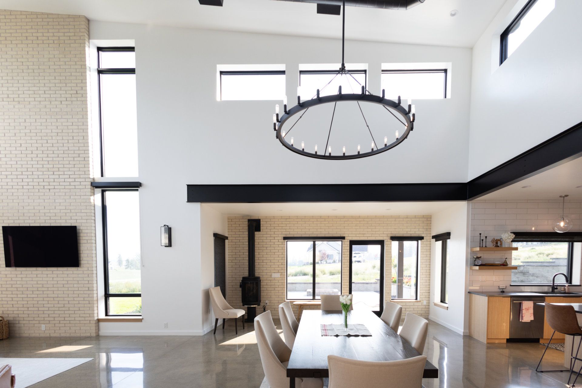 A dining room with a long table and chairs and a chandelier hanging from the ceiling.
