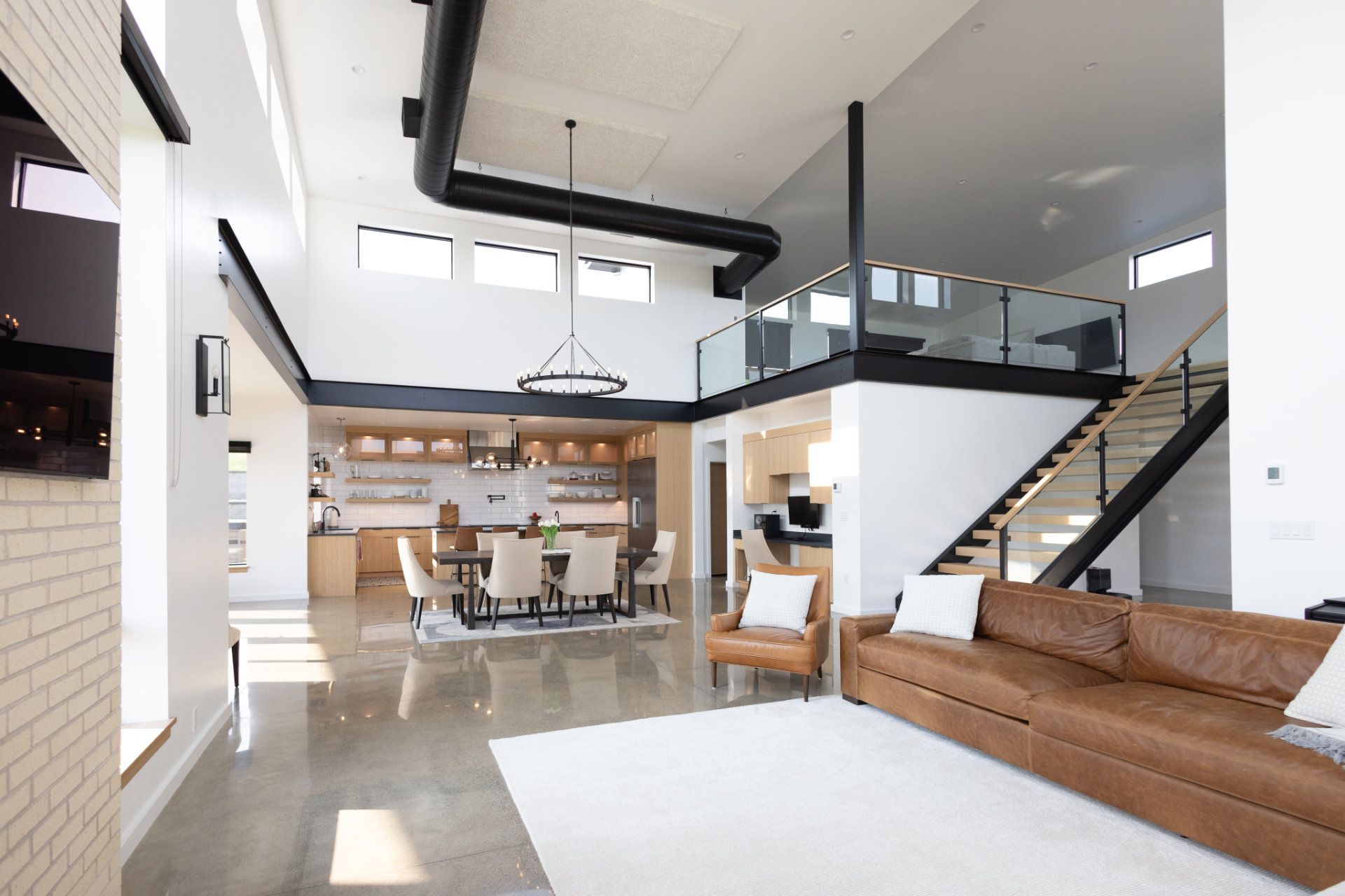 A living room with a brown couch and stairs