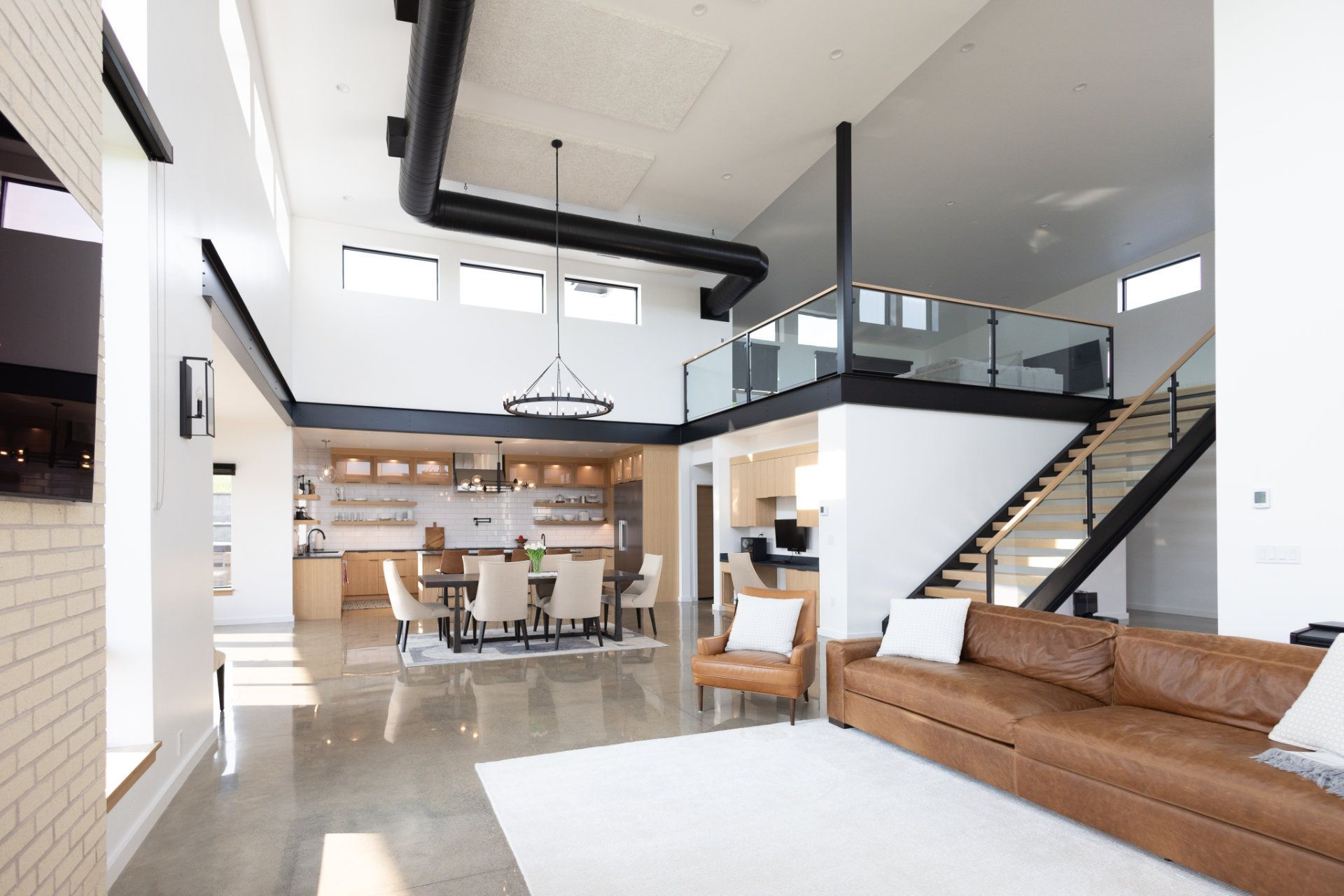 A living room with a couch and chairs and a staircase