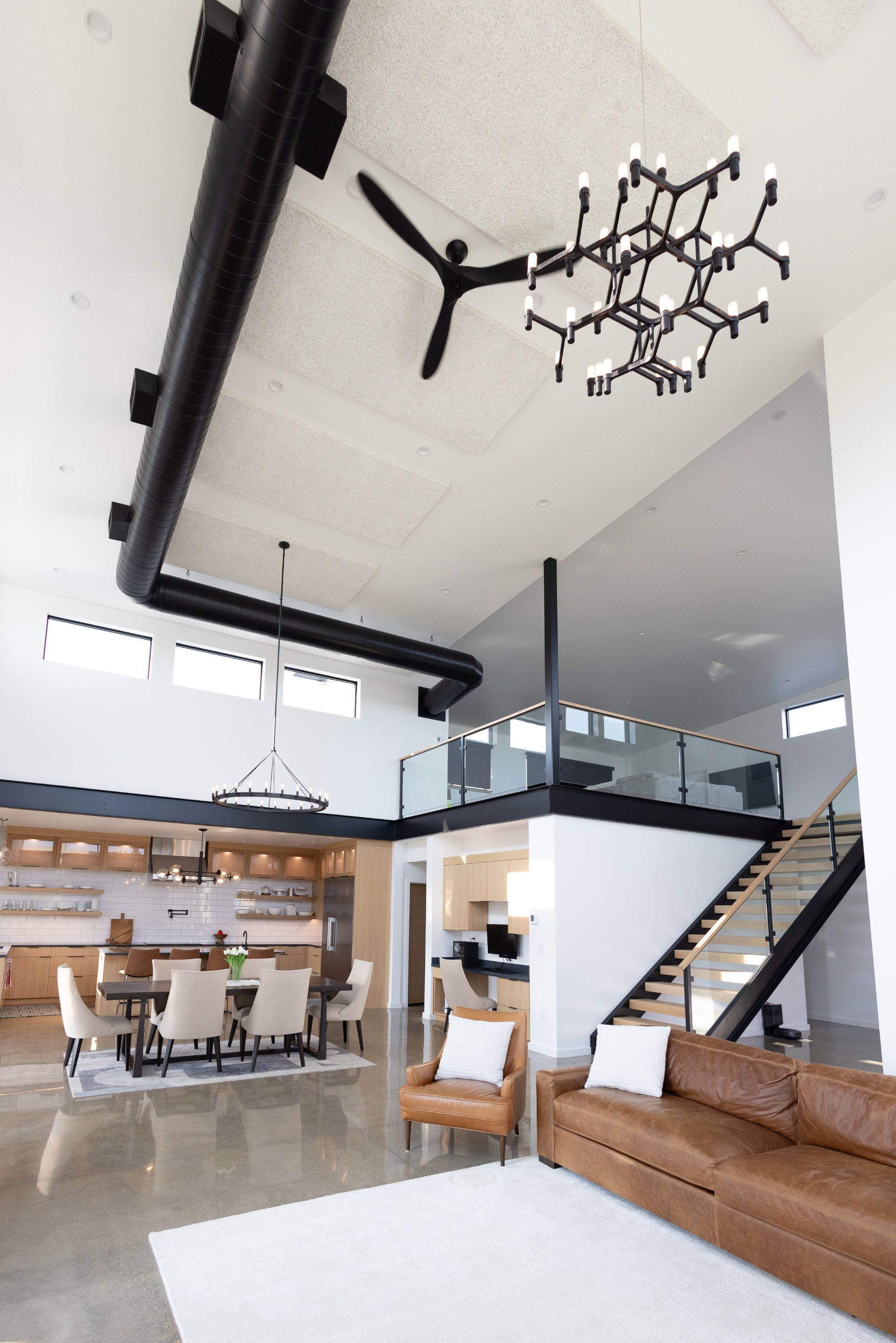 A living room with a couch and chairs and a chandelier hanging from the ceiling