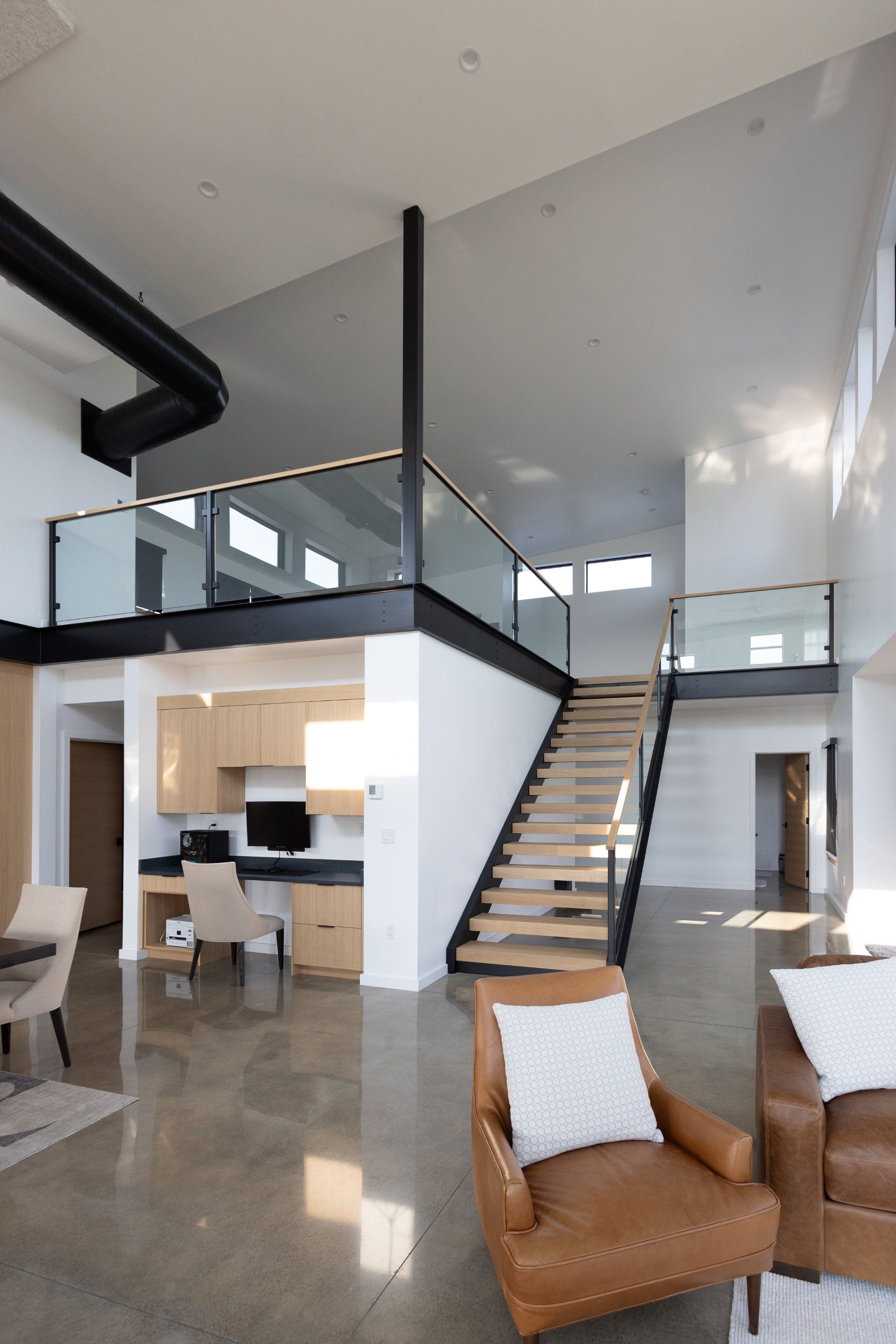 A living room with a staircase leading up to the second floor