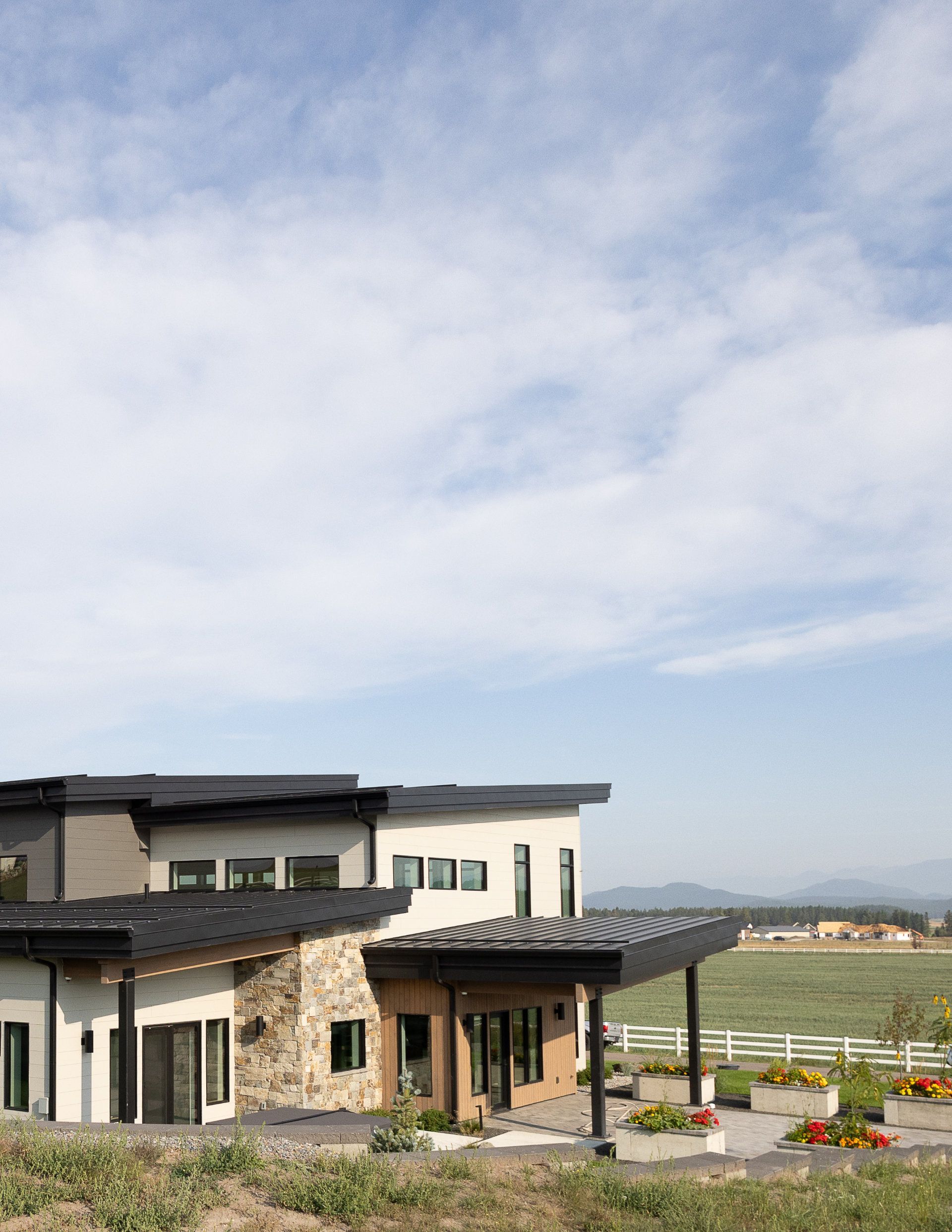 A large house is sitting on top of a grassy hill.