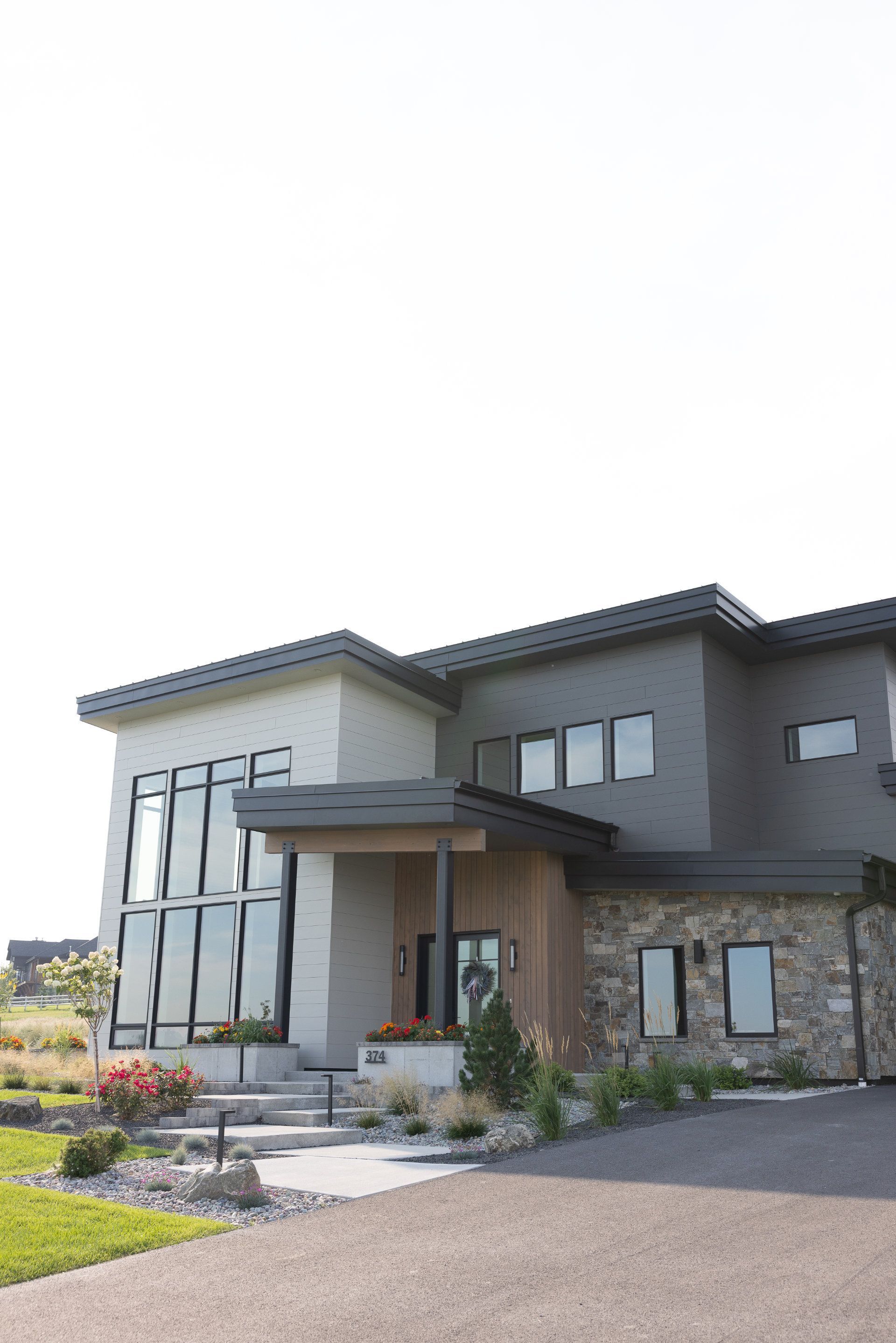 A large house with a lot of windows and a driveway in front of it.
