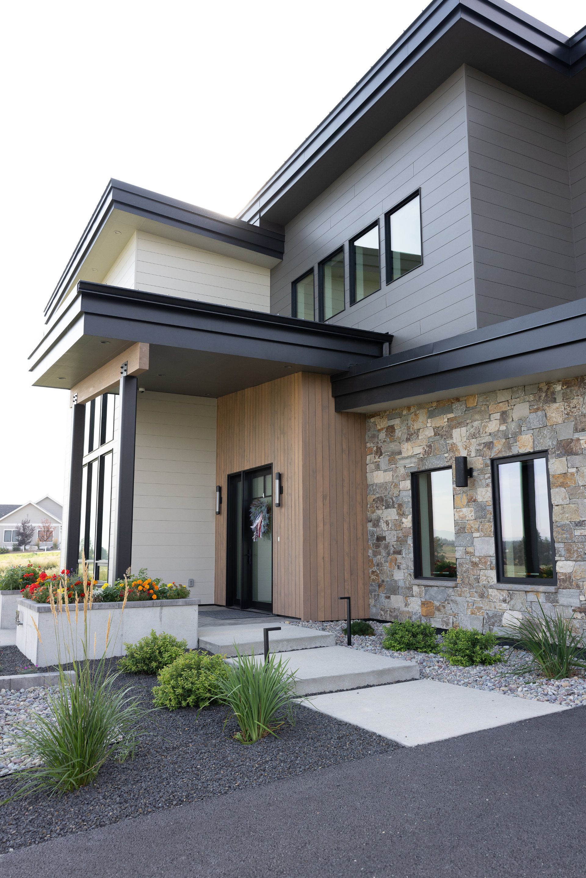 A large house with a stone wall and a wooden porch.