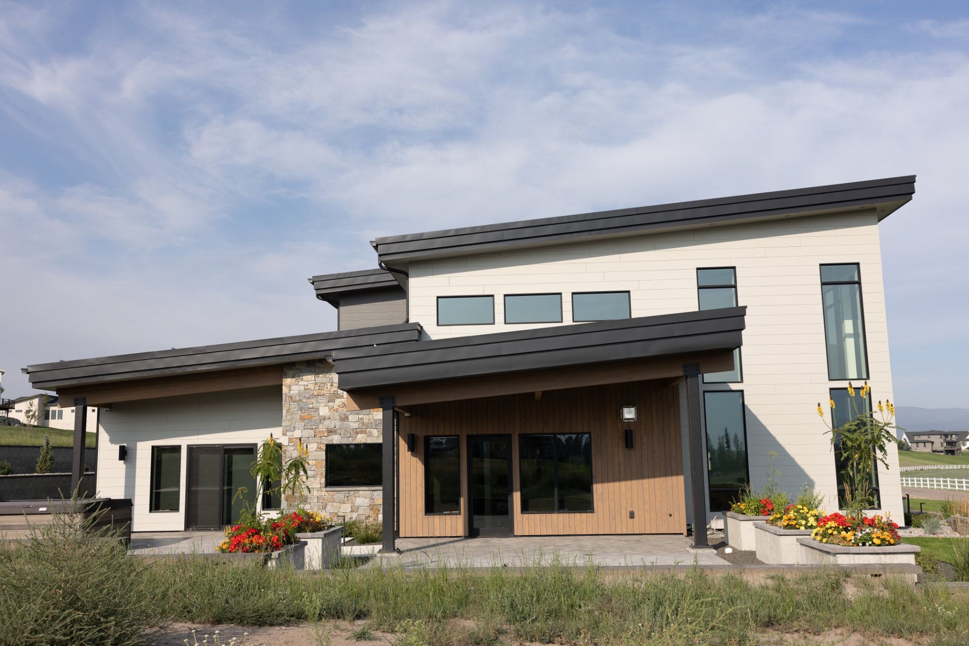A large white house with a black roof and a lot of windows