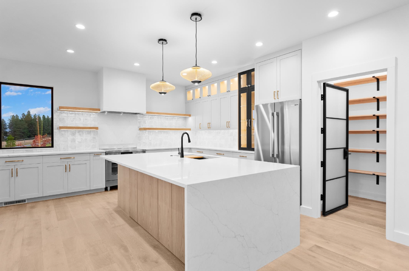 A kitchen with white cabinets and a large island in the middle.