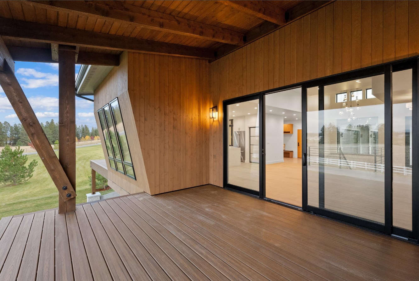 An empty deck with sliding glass doors in a house.