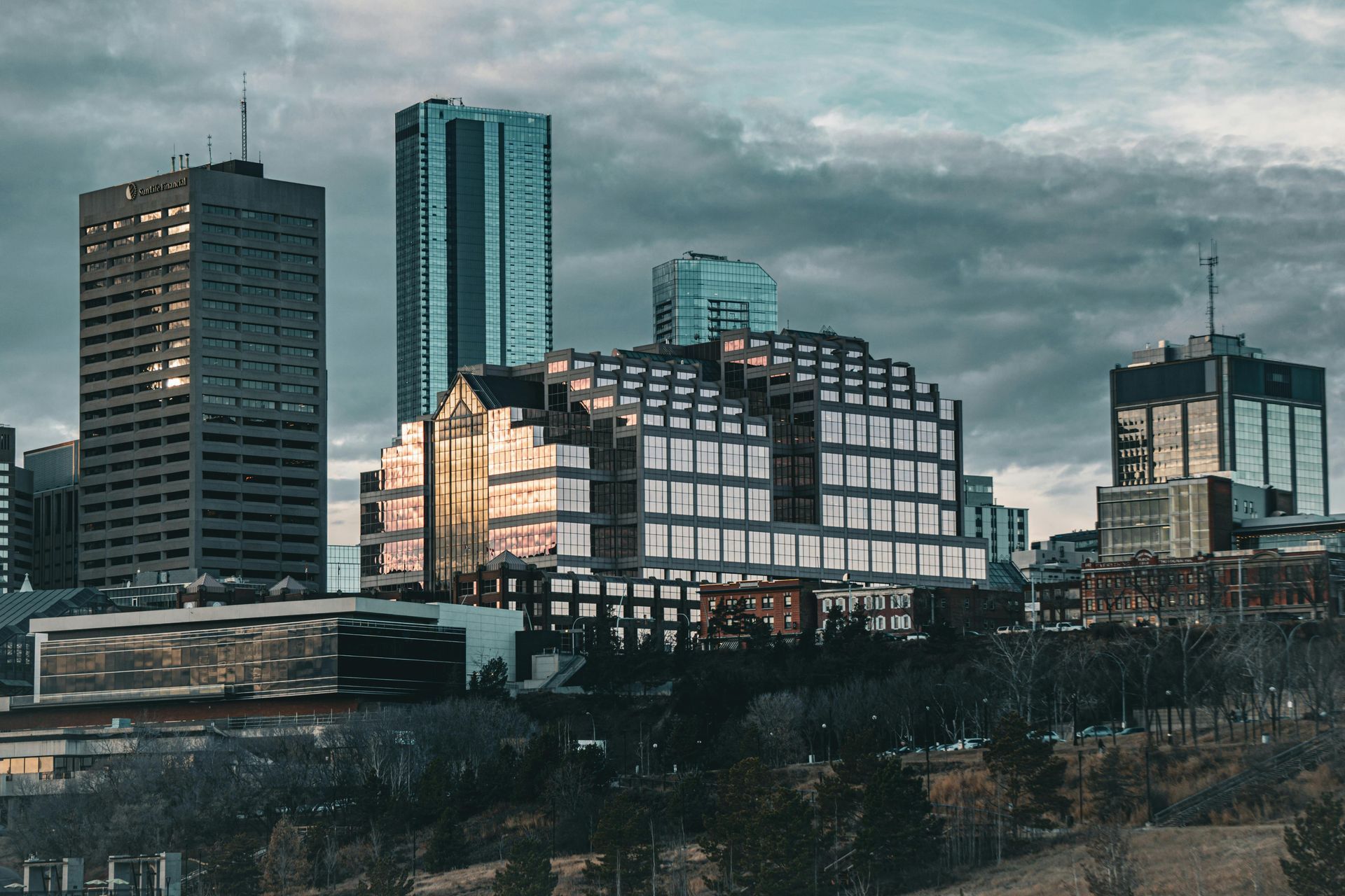 City skyline with modern buildings under a cloudy sky.