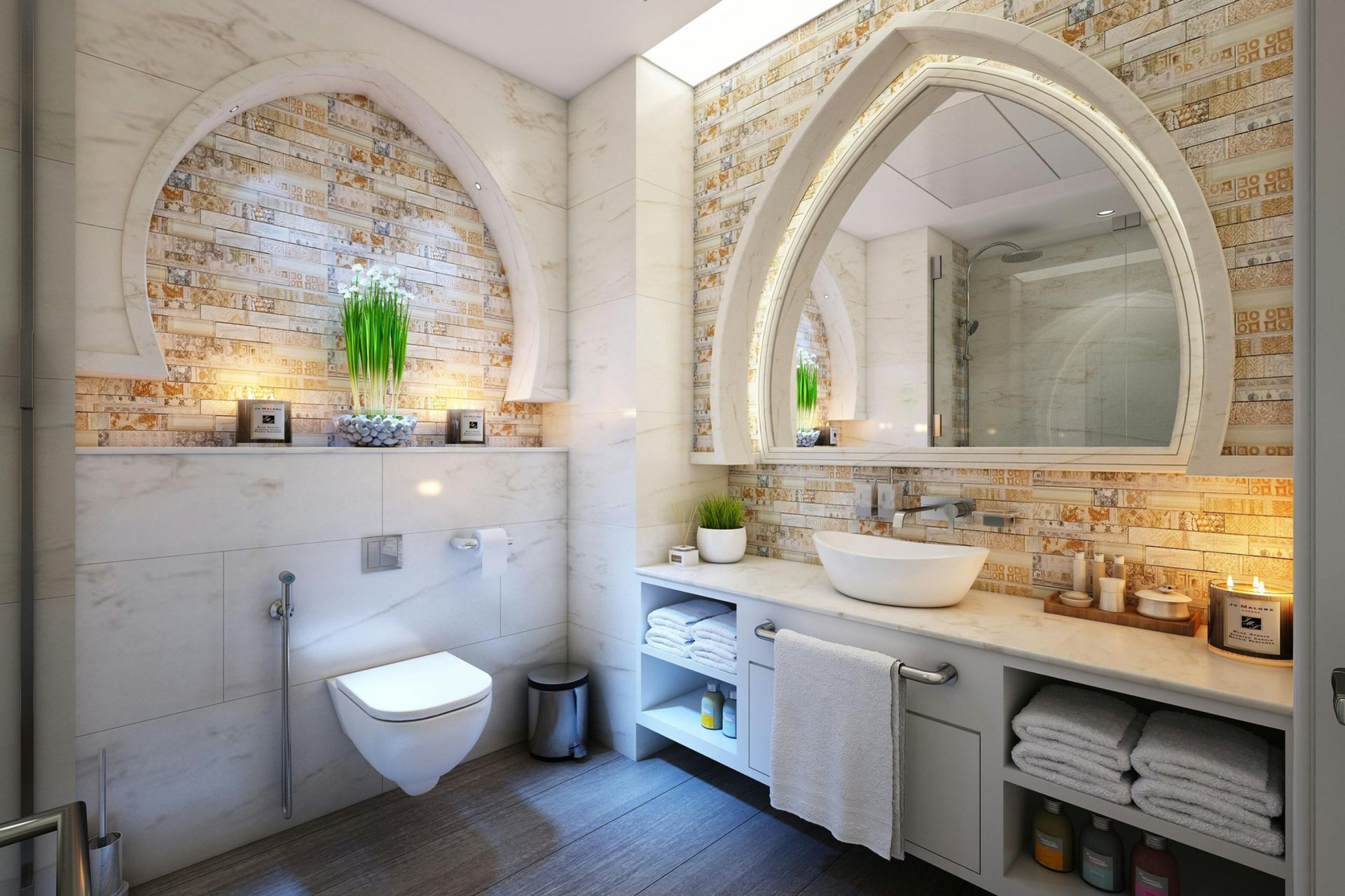 Elegant bathroom with arched mirror, white sink, and stone-like wall accents.