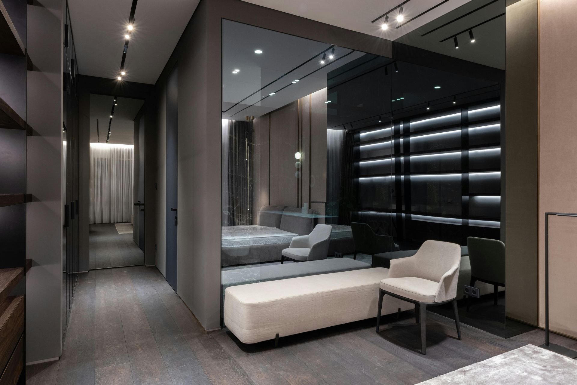 Modern gray and beige interior with a seating area, a mirror, and track lighting.